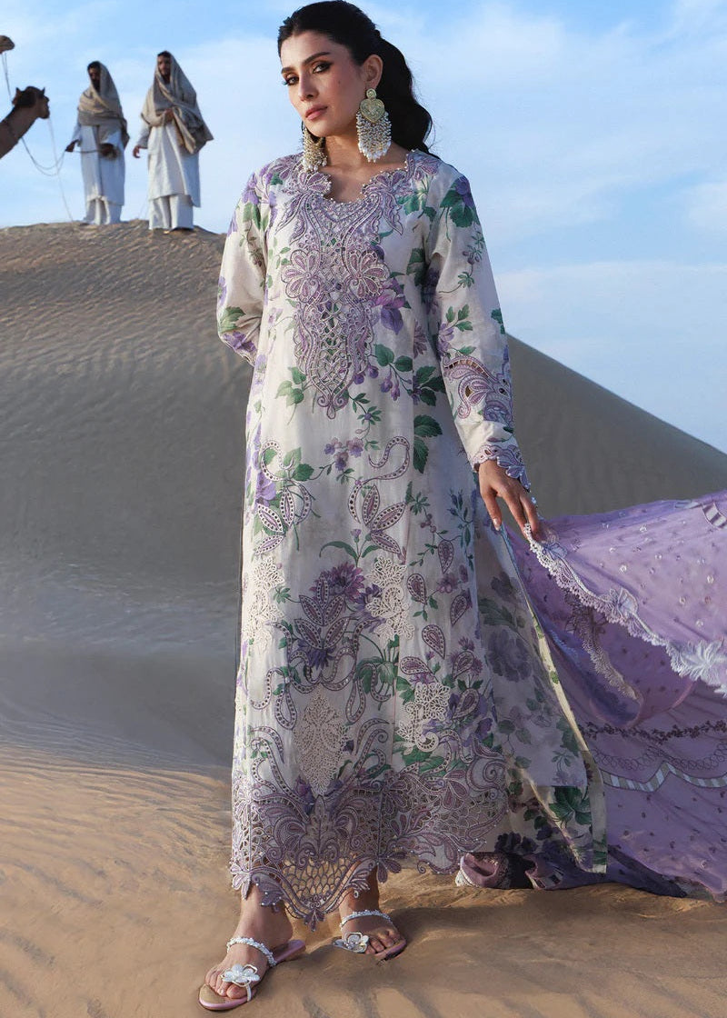Woman in a floral dress standing on sand dunes with people in the background
