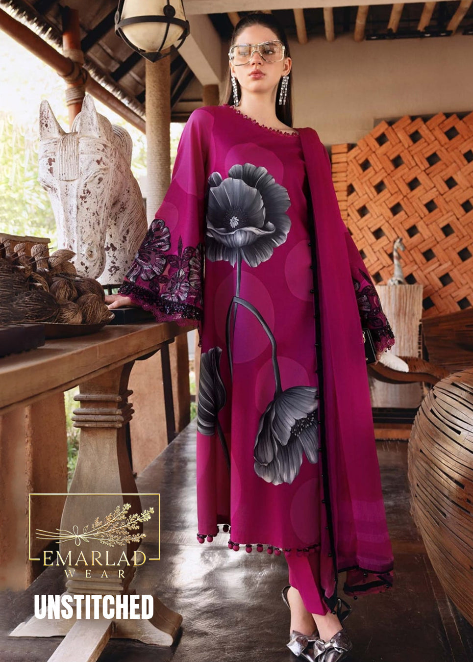 Woman wearing a vibrant pink outfit with floral designs in an outdoor setting, Emralad Wear brand visible.