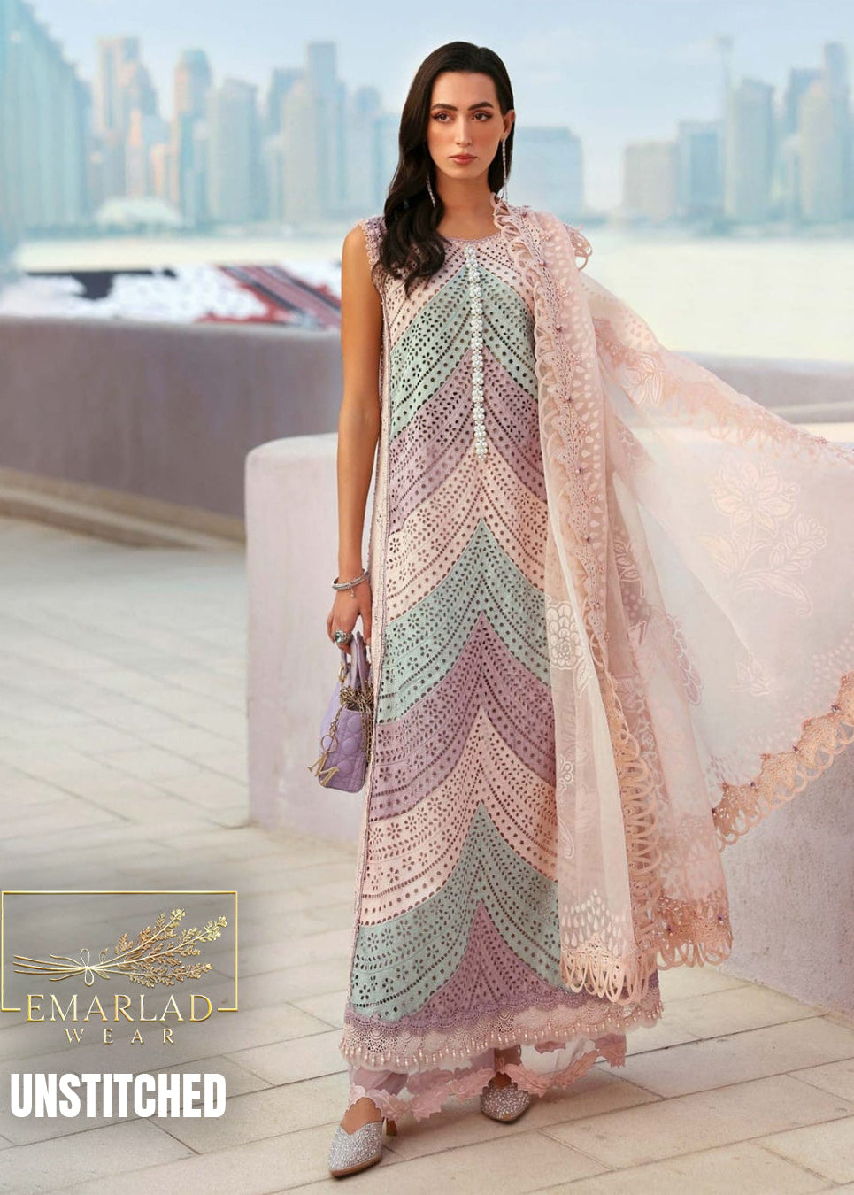 Woman wearing a colorful dress with a cityscape in the background, featuring Emarlad Wear branding.