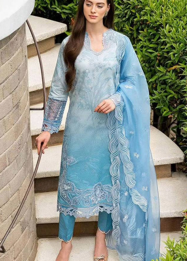 Woman wearing a light blue embroidered outfit with a dupatta, standing outdoors.