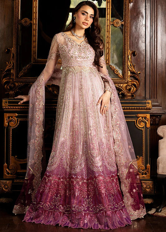 Woman in a pink and purple embroidered dress sitting in front of an ornate mirror.
