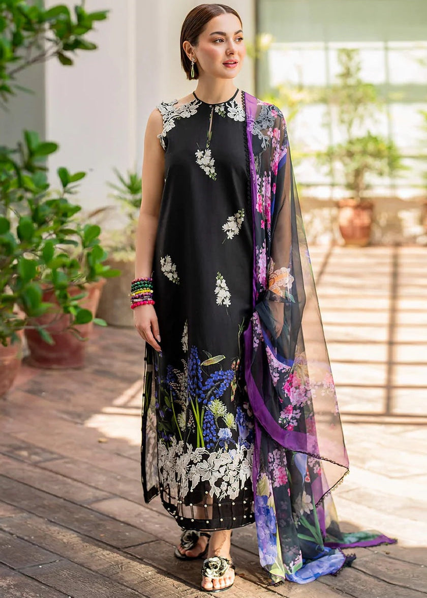 Woman wearing a black floral dress with a colorful scarf in an outdoor setting