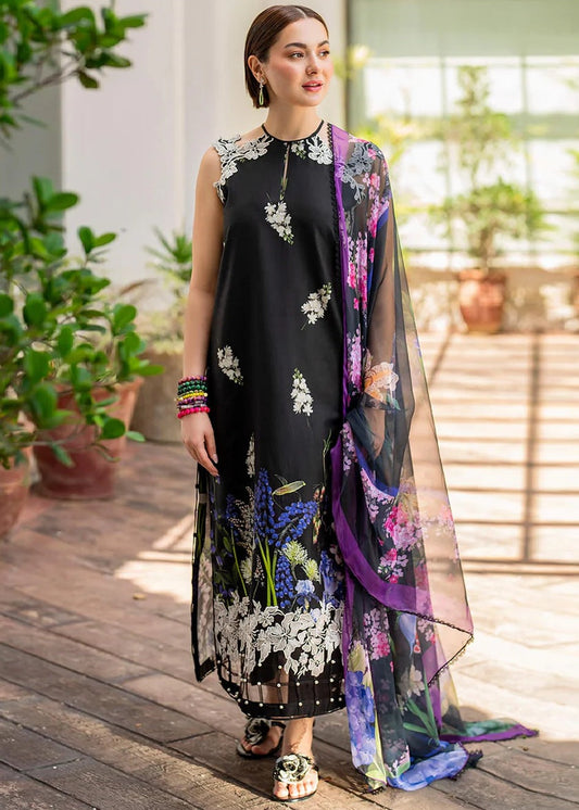 Woman wearing a black floral dress with a colorful scarf in an outdoor setting