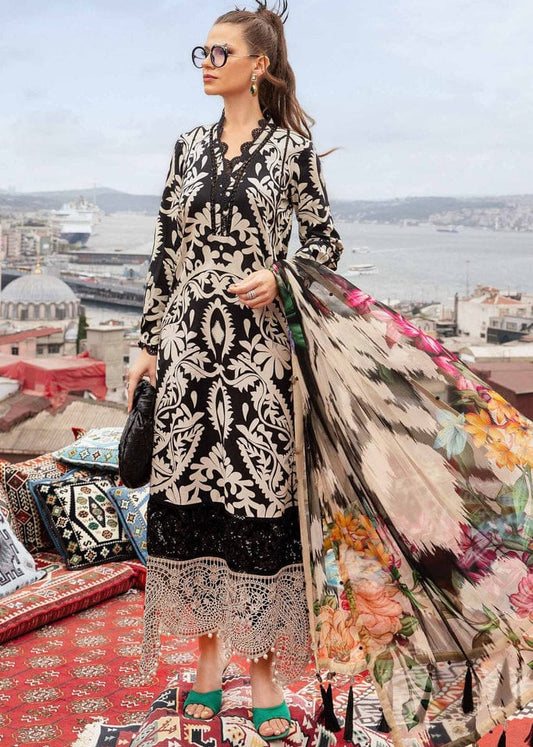 Woman in a black and white patterned dress with a floral coat standing on a rooftop with a cityscape view.